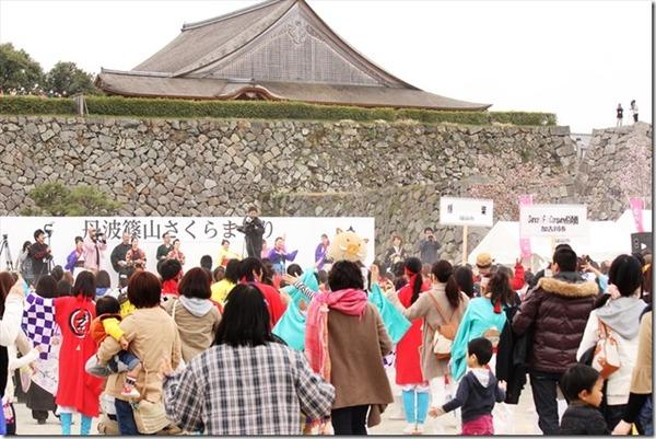 さくらまつりのステージや会場でよさこい踊りを踊っている人々の写真